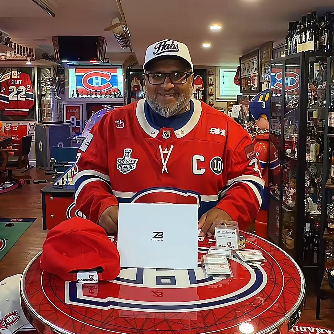 Sunny Peetush holding a ZippyBack™ box and cap, with HabsCave memorabilia in the background