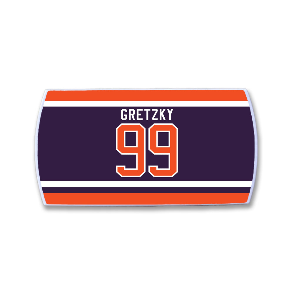 A rectangular ZippyBack™ patch with dark blue, orange, and white stripes, featuring "Wayne Gretzky" and the number 99 in bold orange and white— a Limited Edition tribute to hockey’s greatest.
