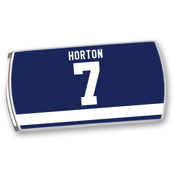 The ZippyBack™ Tim Horton hockey jersey is dark blue with white HORTON name and 7, plus a white horizontal stripe near the bottom, honoring legendary defenseman Tim Horton.