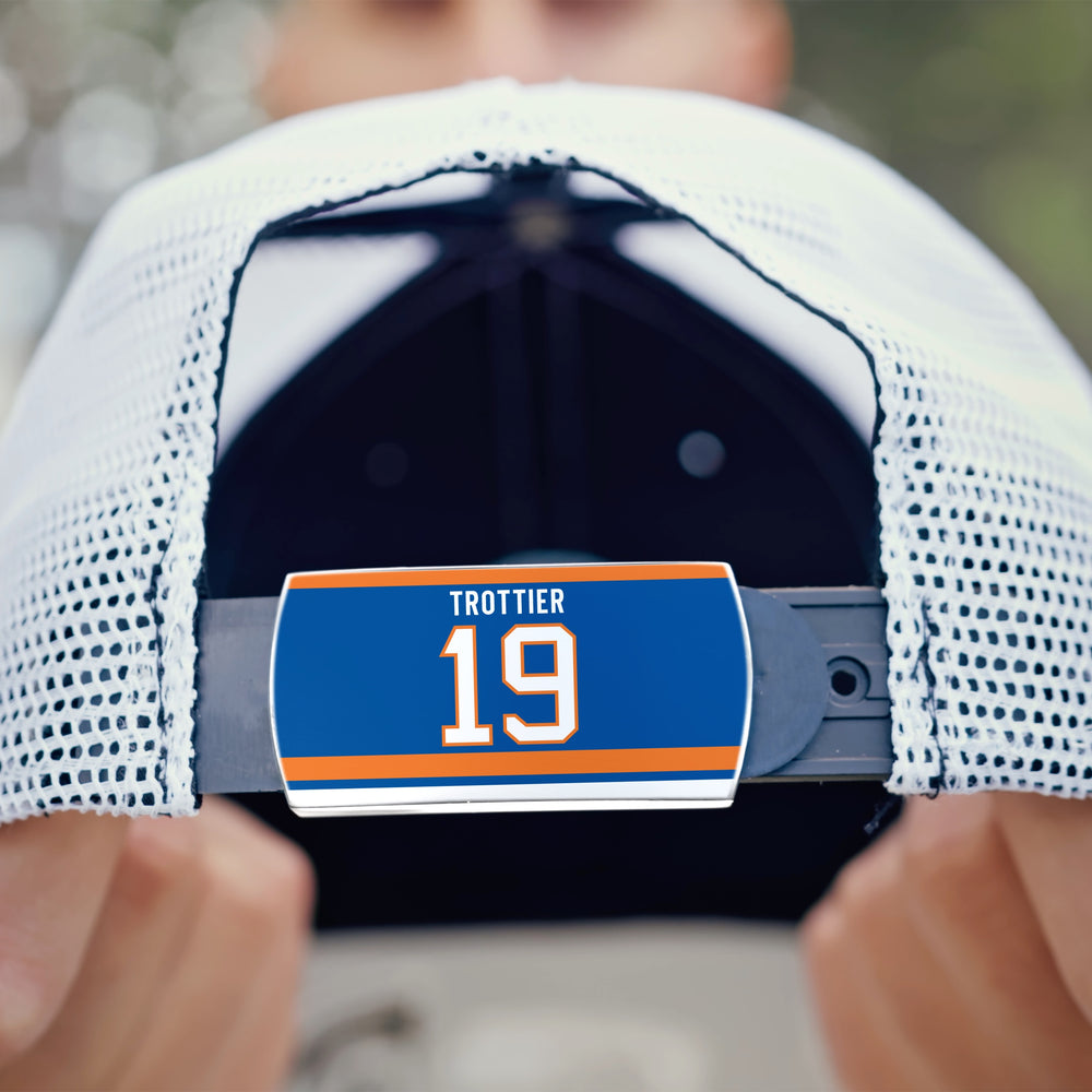 A close-up of a ZippyBack™ mesh baseball cap features a label with Bryan Trottier’s name and number 19 in blue, orange, and white—honoring his iconic legacy.