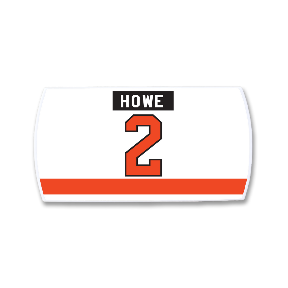 The ZippyBack™ Mark Howe nameplate is a rectangular white hockey patch with "HOWE" in black above a big red 2, and a bold red stripe near the bottom, honoring Mark Howe’s elite blue line defense legacy.