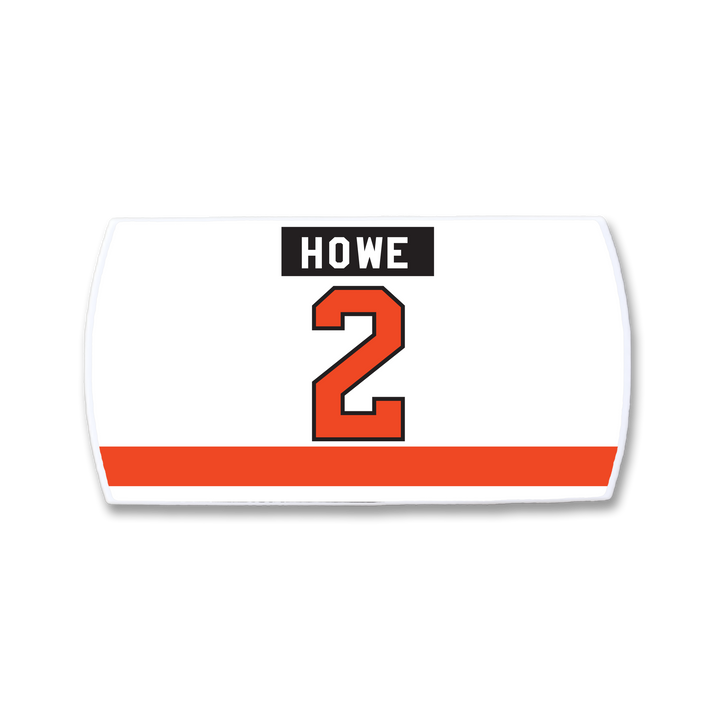 The ZippyBack™ Mark Howe nameplate is a rectangular white hockey patch with "HOWE" in black above a big red 2, and a bold red stripe near the bottom, honoring Mark Howe’s elite blue line defense legacy.