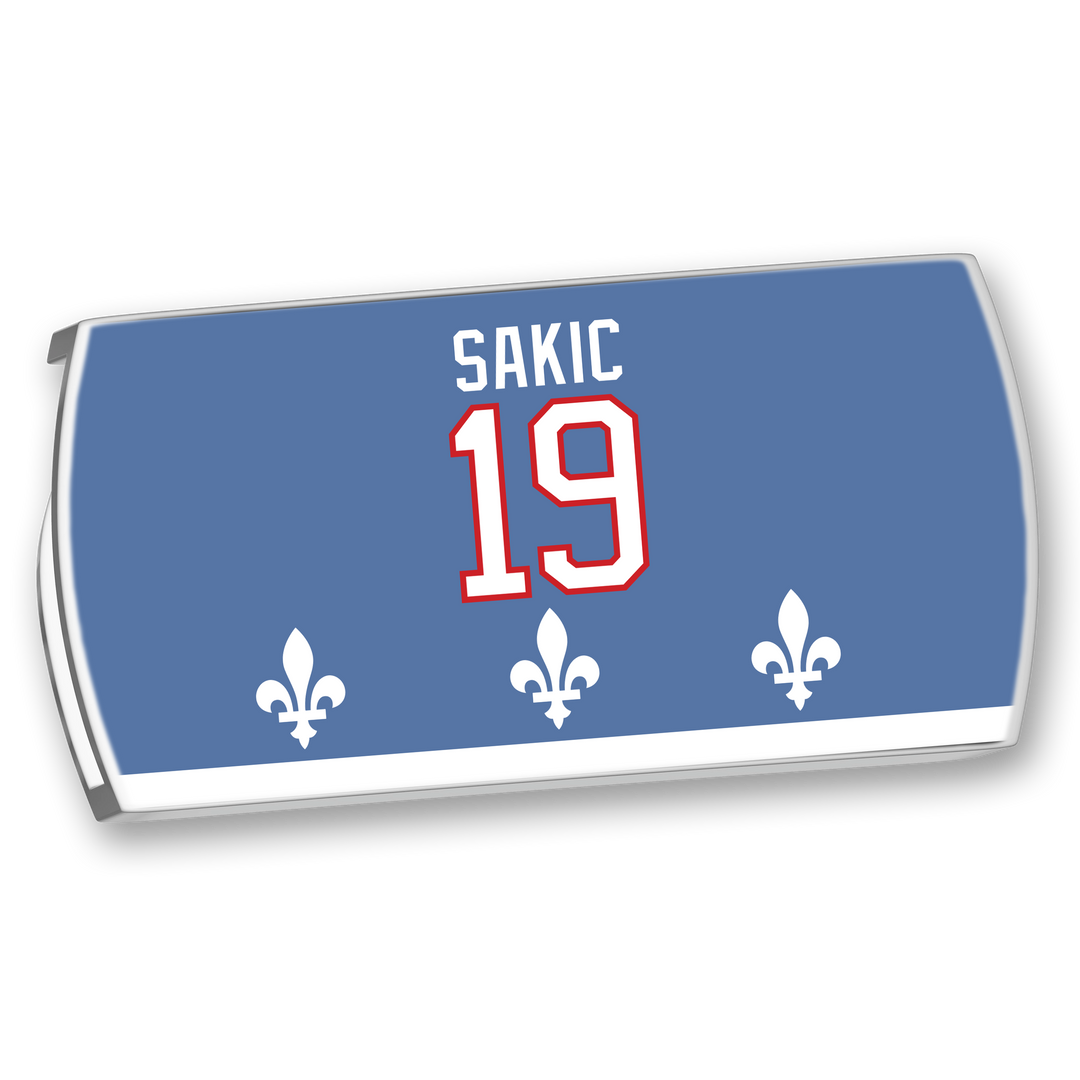 The ZippyBack™ Joe Sakic blue hockey nameplate features white "SAKIC," a red-outlined 19, and three white fleur-de-lis at the bottom, honoring his elite vision and legendary wrist shot.