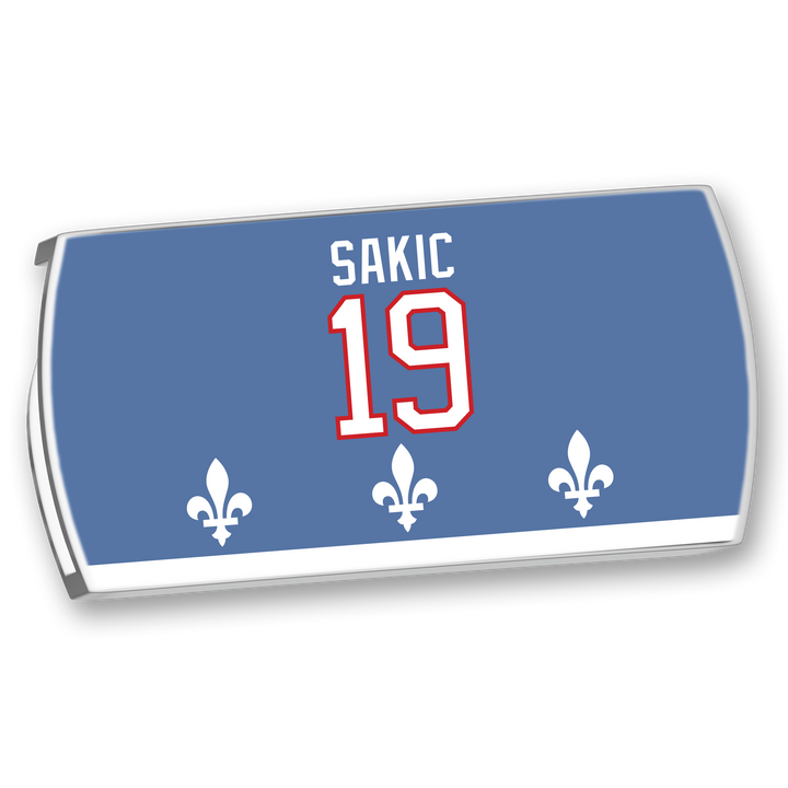 The ZippyBack™ Joe Sakic blue hockey nameplate features white "SAKIC," a red-outlined 19, and three white fleur-de-lis at the bottom, honoring his elite vision and legendary wrist shot.