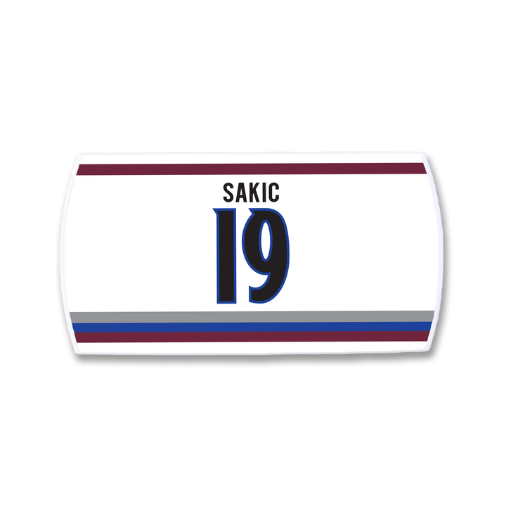 The ZippyBack™ Joe Sakic white hockey jersey nameplate features SAKIC above number 19 in blue/black, bordered by maroon, blue, and gray stripes—a tribute to his elite vision and legendary play.