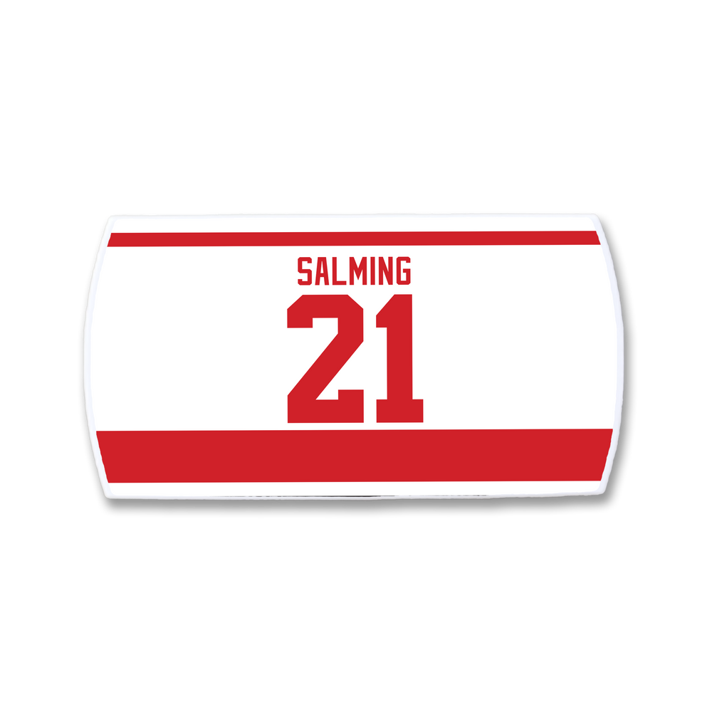 A ZippyBack™ Börje Salming white hockey jersey nameplate with bold red "SALMING" and 21, featuring red borders—a tribute to his hockey resilience, skill, and toughness.