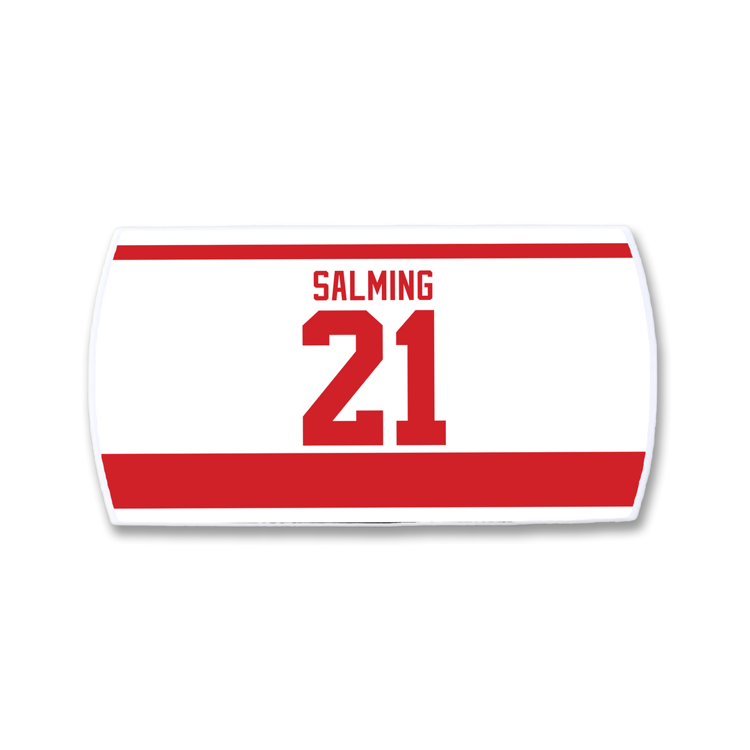A ZippyBack™ Börje Salming white hockey jersey nameplate with bold red "SALMING" and 21, featuring red borders—a tribute to his hockey resilience, skill, and toughness.