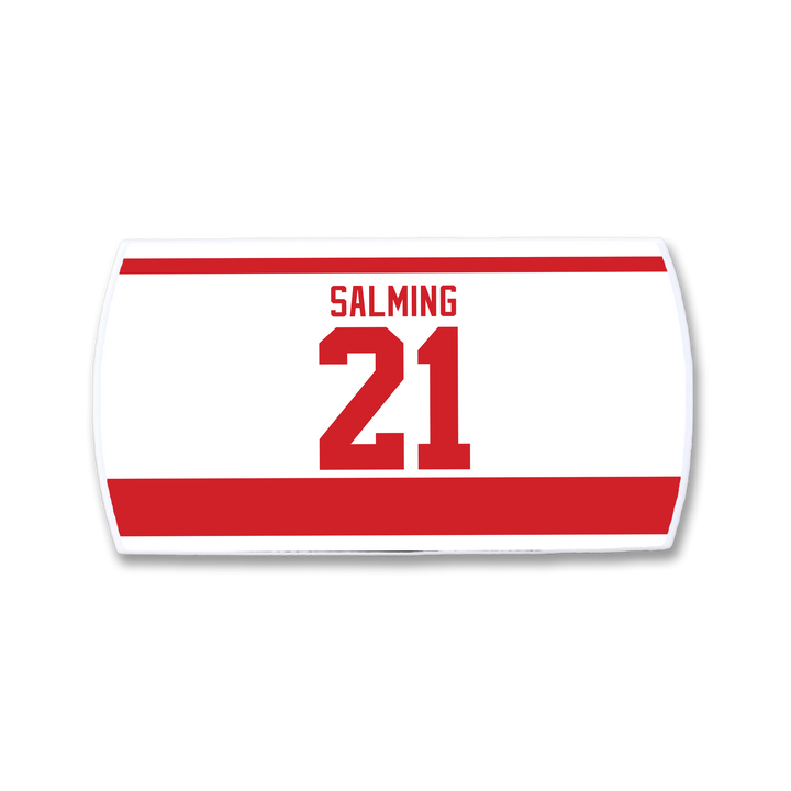 A ZippyBack™ Börje Salming white hockey jersey nameplate with bold red "SALMING" and 21, featuring red borders—a tribute to his hockey resilience, skill, and toughness.