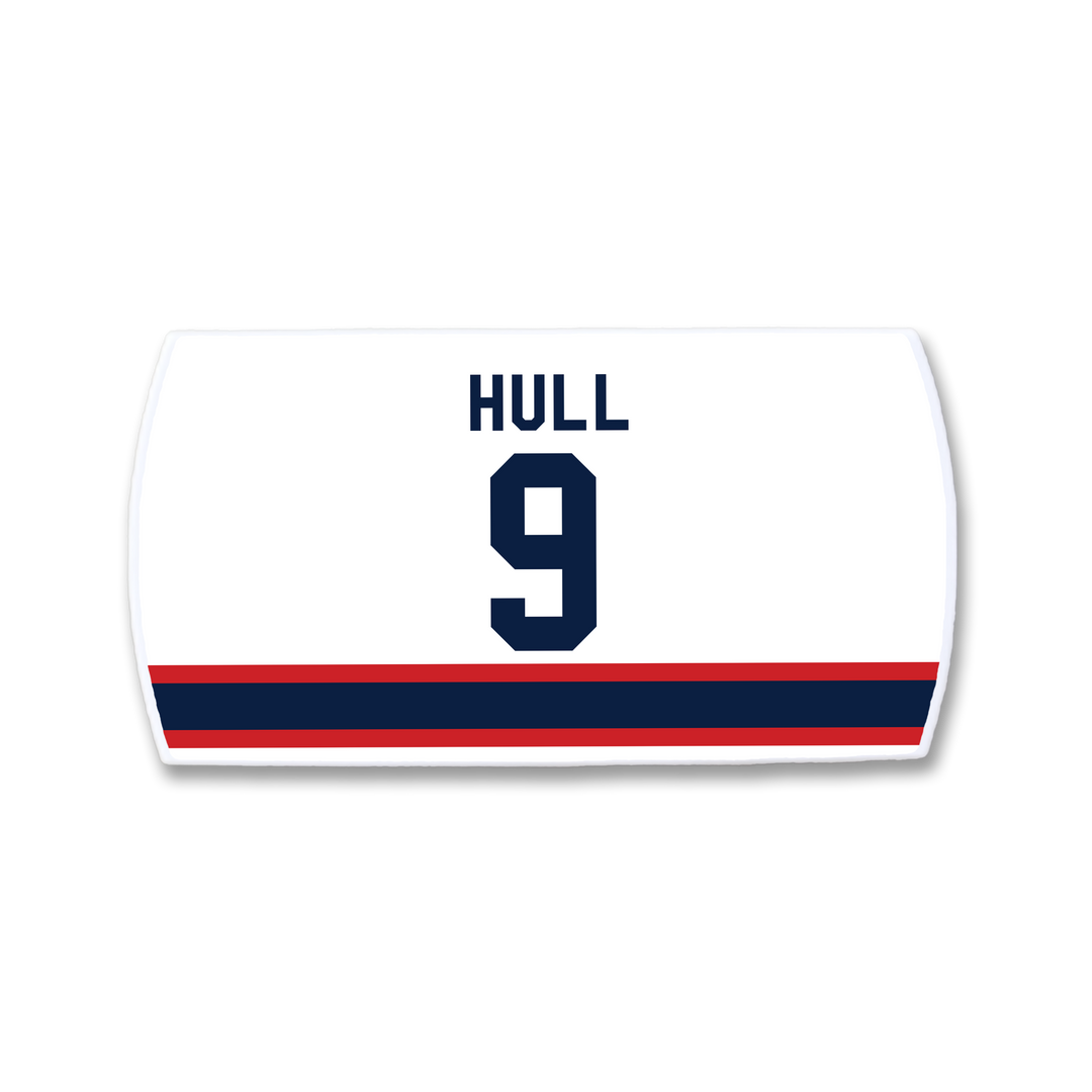 Celebrate Bobby Hull with a ZippyBack™ white hockey jersey nameplate featuring "HULL" and the number 9 in navy blue, above red and navy stripes—honoring the legendary scorer.