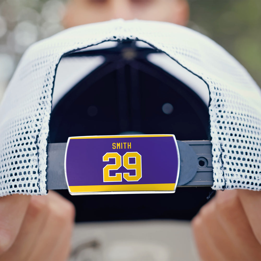 A close-up of the back of a white mesh ZippyBack™ baseball cap shows a purple and gold Billy Smith label with the number 29 on the adjustable strap, honoring his clutch hockey performances.