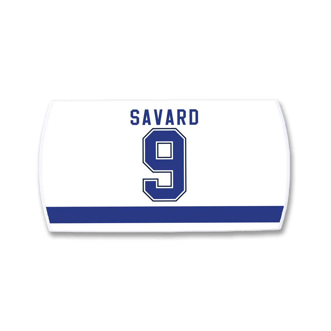 A white ZippyBack™ hockey jersey nameplate featuring "SAVARD" and number 9 in bold blue letters with white trim above a thick blue stripe—a tribute to Denis Savard’s legendary skills.