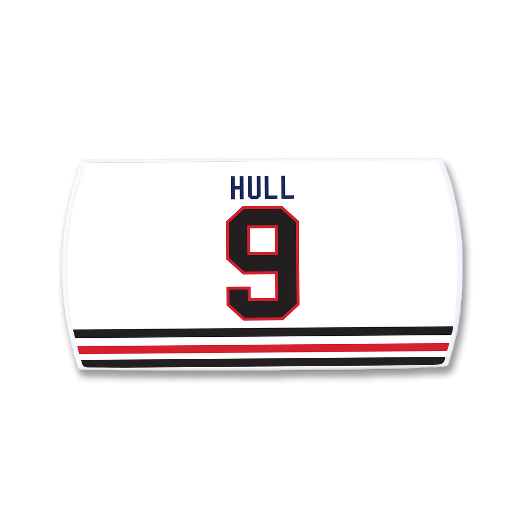A ZippyBack™ Bobby Hull white hockey jersey features "HULL" in blue, the number 9 in black and red, and two black-red stripes near the bottom—a tribute to the legendary goal scorer.