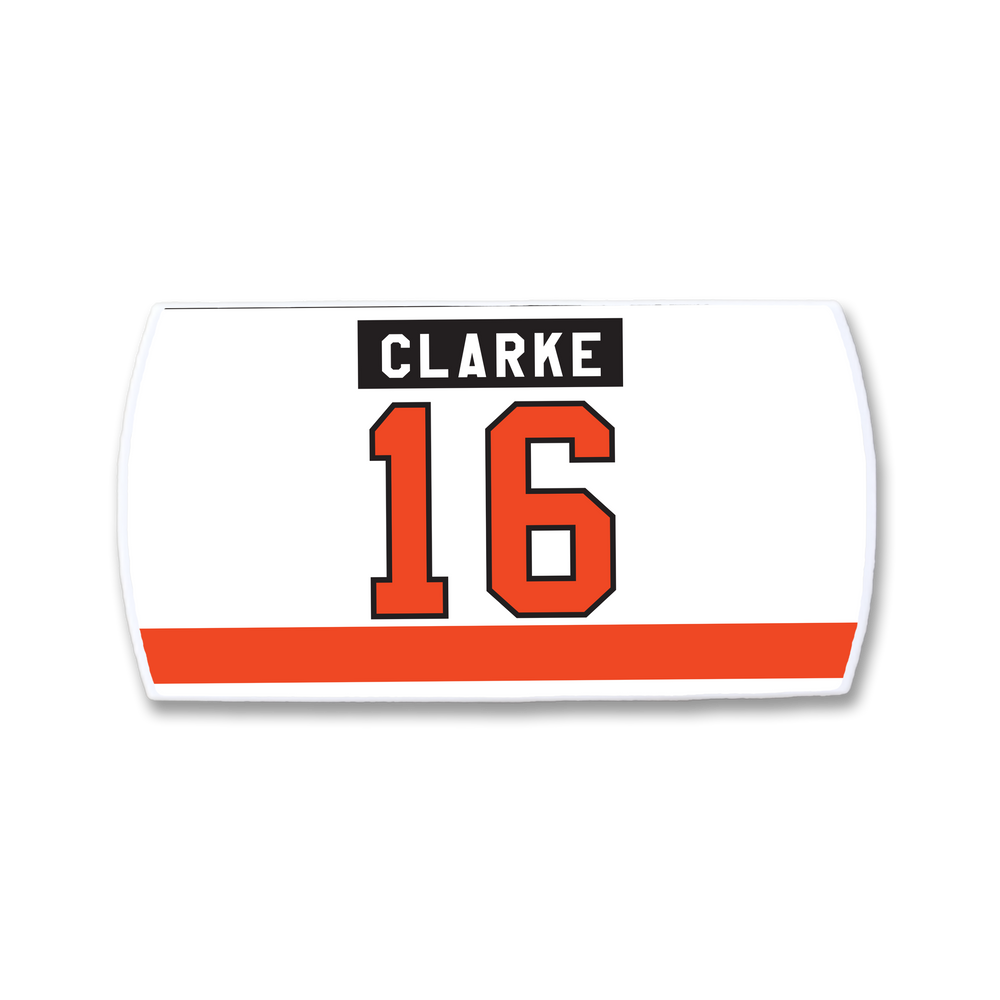 A white ZippyBack™ rectangular hockey jersey nameplate for Bobby Clarke, featuring "CLARKE" in a black box with white text, a large orange number 16 outlined in black, and an orange stripe at the bottom.