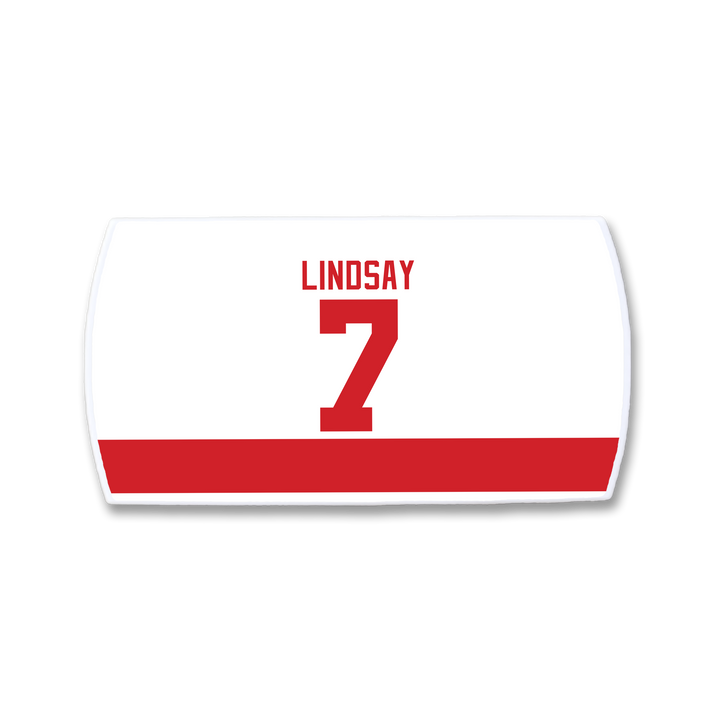 A ZippyBack™ Ted Lindsay rectangular white sports jersey nameplate features a bold red bottom stripe, with LINDSAY and the number 7 in red above it, honoring hockey winger Ted Lindsay.