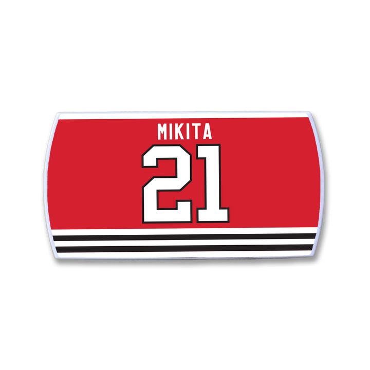 ZippyBack™ Stan Mikita red hockey jersey nameplate features his name in white above a large white number 21 outlined in black, with bold black and white horizontal stripes at the bottom.