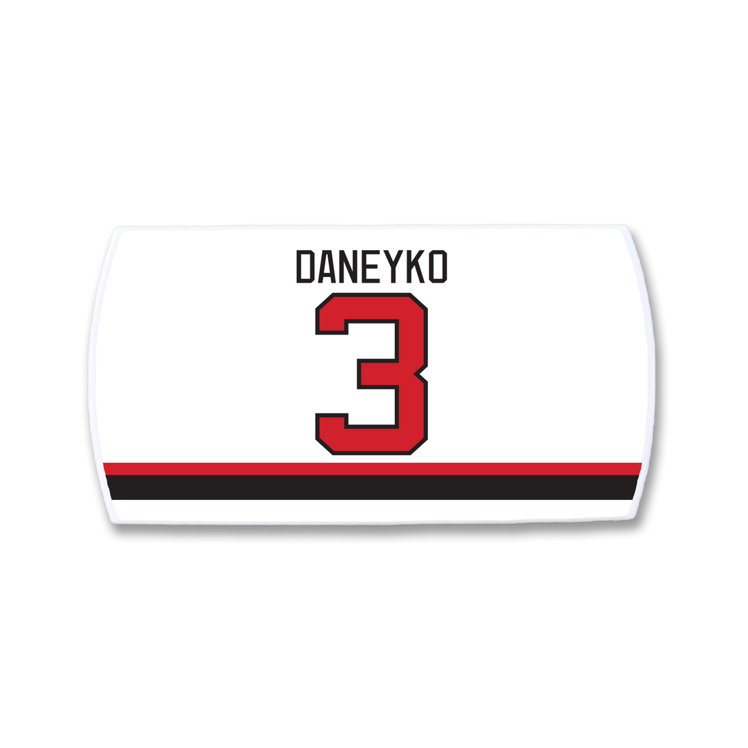 The ZippyBack™ Ken Daneyko hockey jersey nameplate features DANEYKO in black above a bold red 3, with striking black and red stripes near the bottom, honoring his defensive legacy.