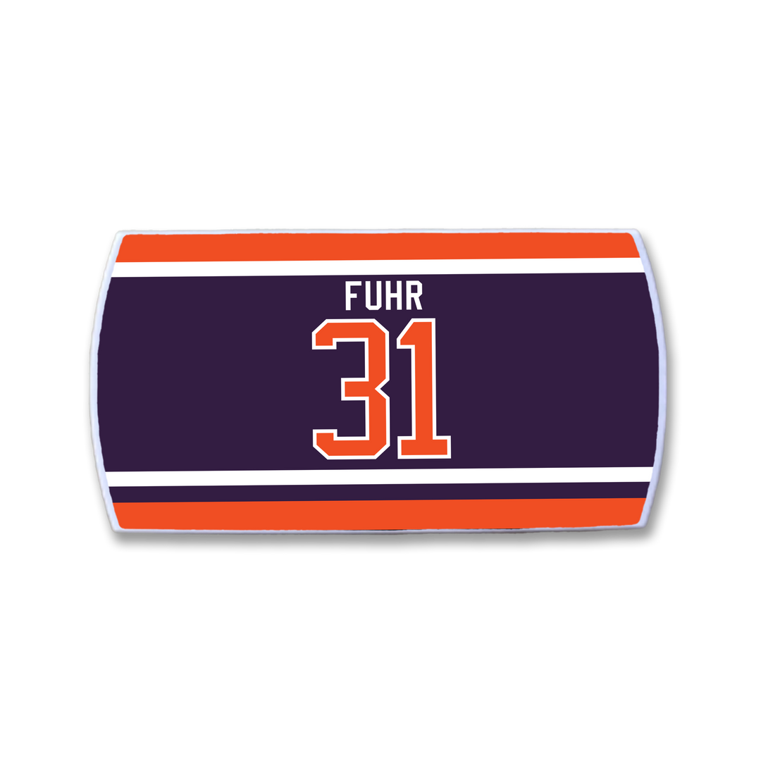 The ZippyBack™ Grant Fuhr hockey jersey nameplate displays "FUHR" and number 31 in bold orange and white on dark blue, bordered by red, orange, and white stripes—a tribute to this legendary goalie.