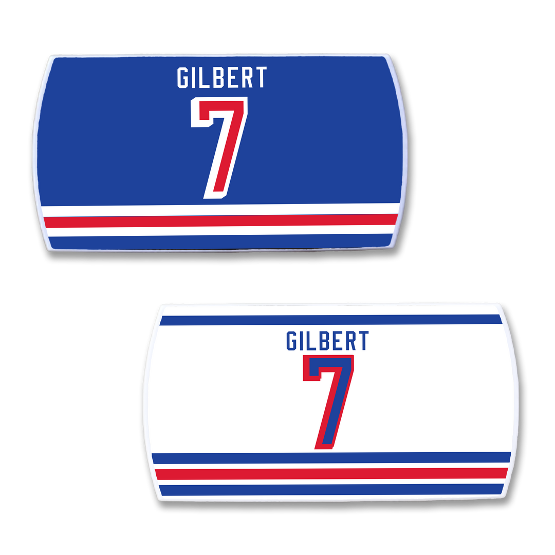 Two ZippyBack™ Rob Gilbert hockey jersey nameplates, one blue and one white, each with GILBERT and the number 7 in bold red and blue plus vivid stripes—perfect for fans of hard-hitting defense.