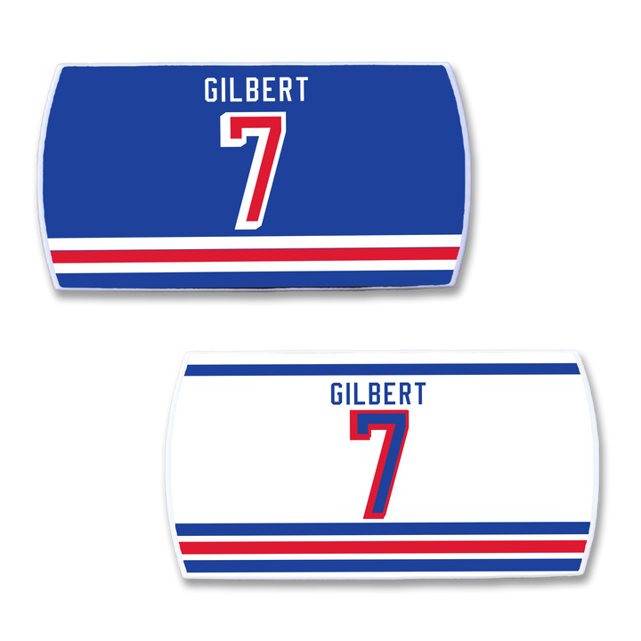 Two ZippyBack™ Rob Gilbert hockey jersey nameplates, one blue and one white, each with GILBERT and the number 7 in bold red and blue plus vivid stripes—perfect for fans of hard-hitting defense.