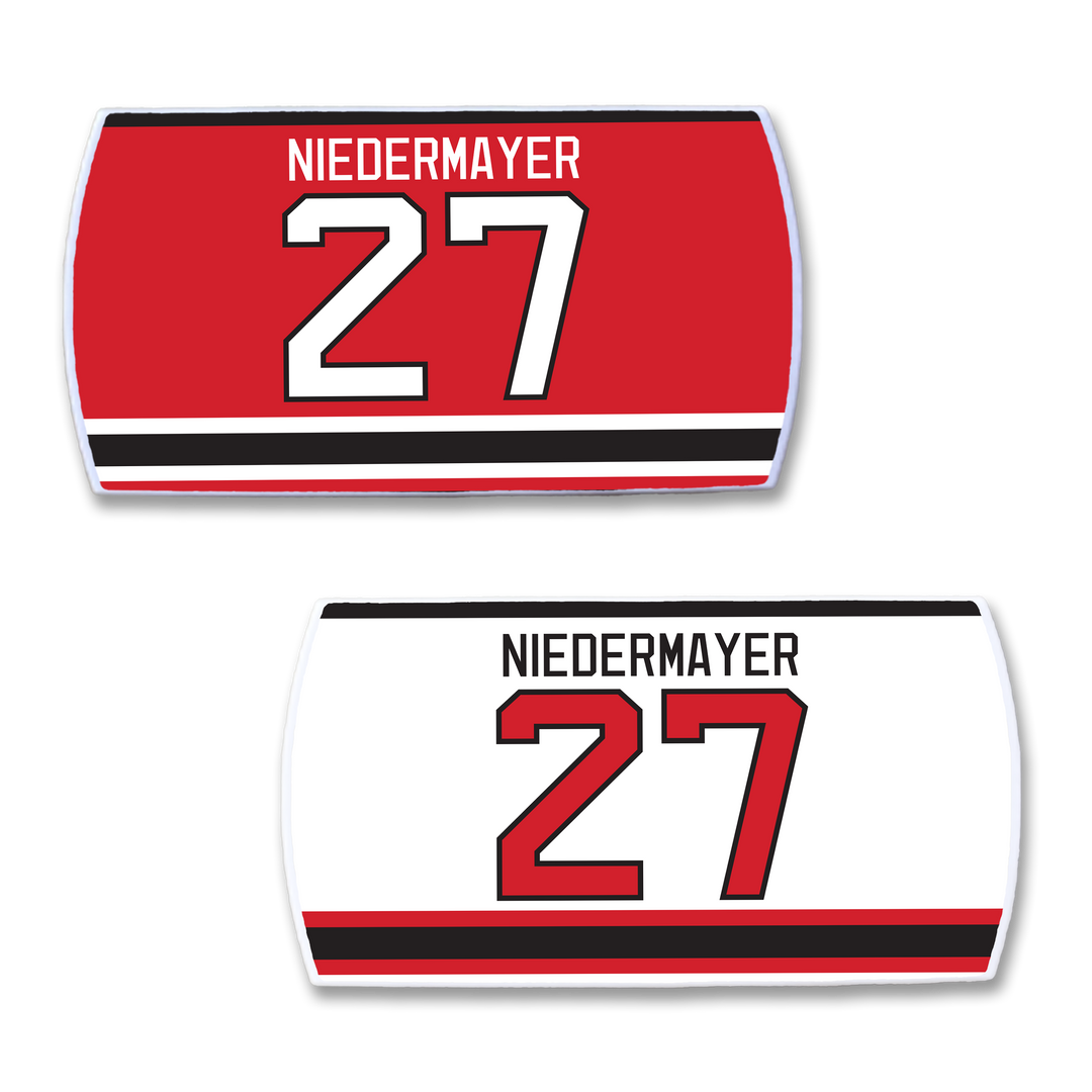 Two ZippyBack™ Scott Niedermayer hockey jersey nameplates—one with a red background, black/white stripes; the other white with black/red stripes—both featuring 27, ideal for true fans.