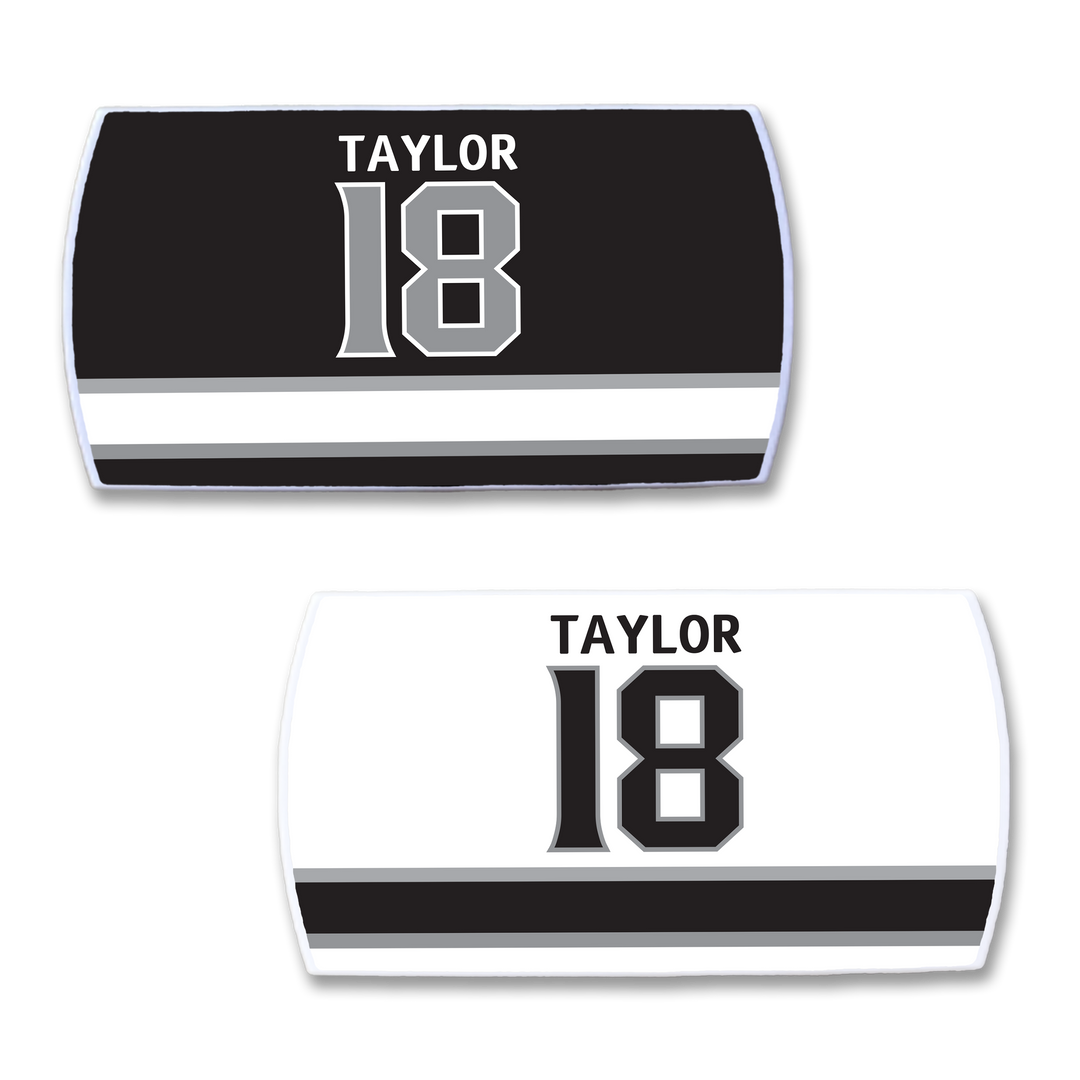 Two ZippyBack™ “Dave Taylor” sports jersey nameplates—one black, one white—feature TAYLOR and 18 above a bold black/gray stripe, honoring the reliable scoring of playmaking forward Dave Taylor.